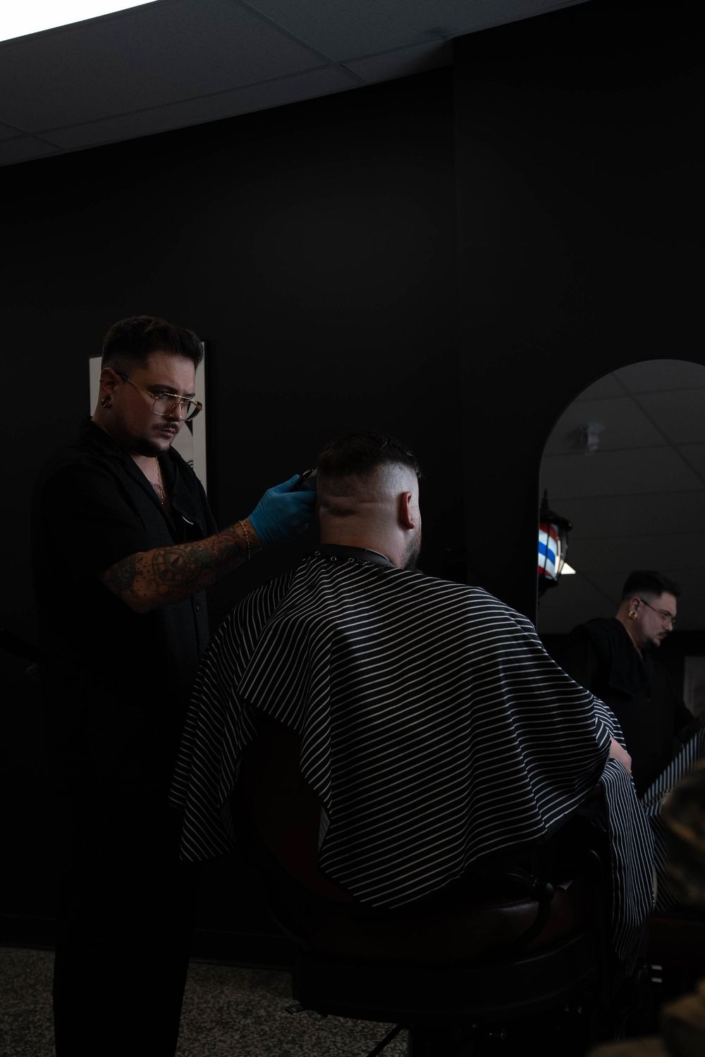 Joey Ouellet réalise un dégradé à la tondeuse au Barbier Privé, devant le miroir en arche